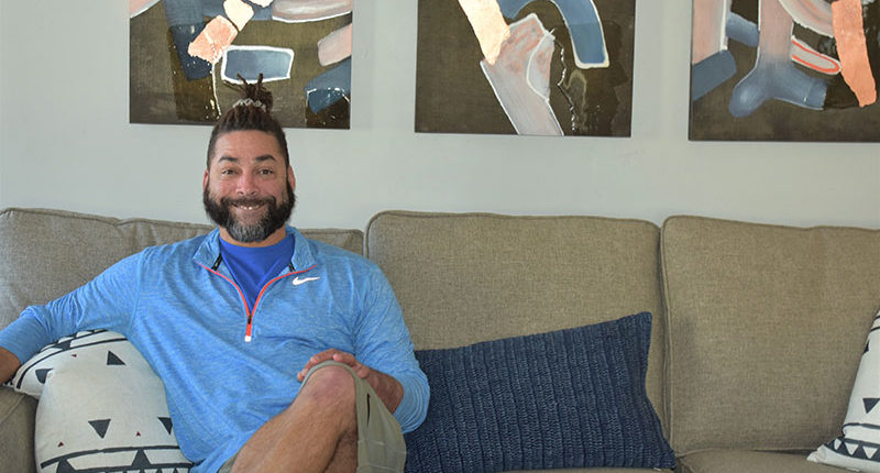 GySgt McQuigg sitting on his newly furnished sofa